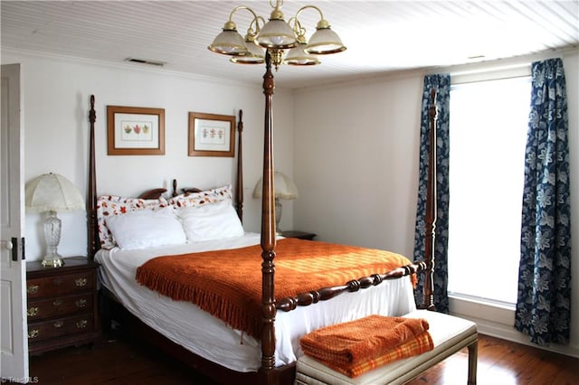 bedroom featuring ornamental molding, dark hardwood / wood-style floors, and a notable chandelier