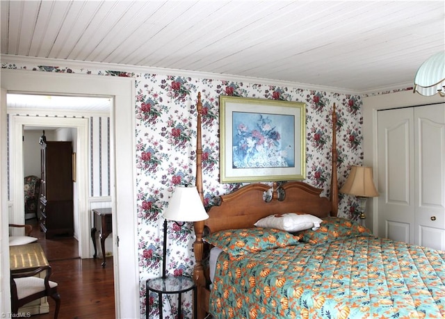 bedroom with wood-type flooring, crown molding, and a closet