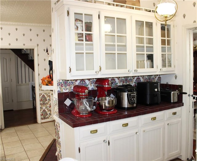 kitchen with tile countertops, white cabinetry, and light tile patterned floors