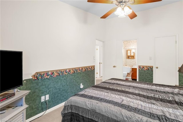 carpeted bedroom with a ceiling fan and ensuite bath