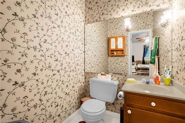 bathroom featuring vanity, toilet, and wallpapered walls