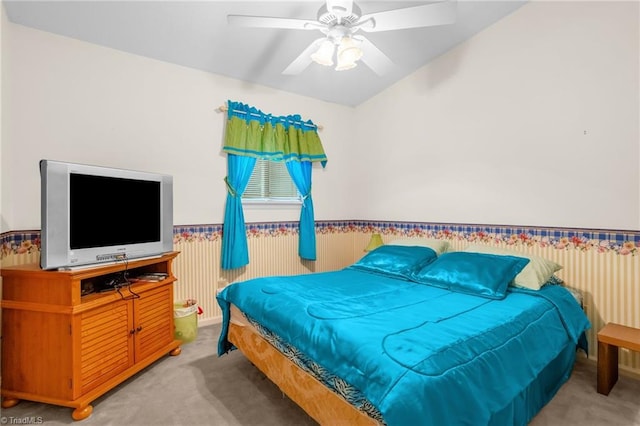 bedroom with light colored carpet, wainscoting, and ceiling fan