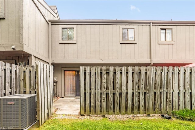rear view of property featuring central air condition unit and fence private yard