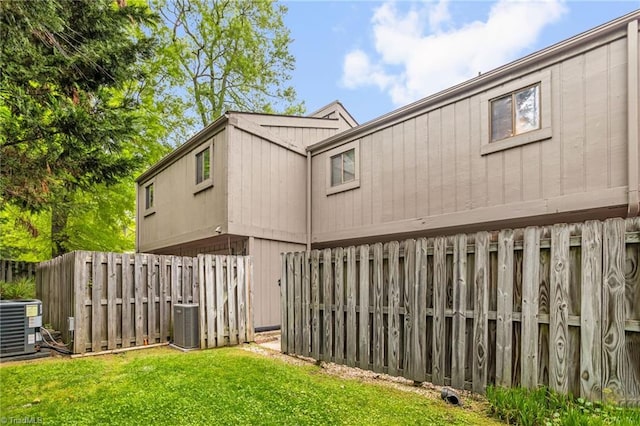 view of home's exterior featuring central air condition unit, fence, and a lawn