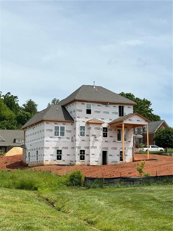 rear view of house featuring a yard