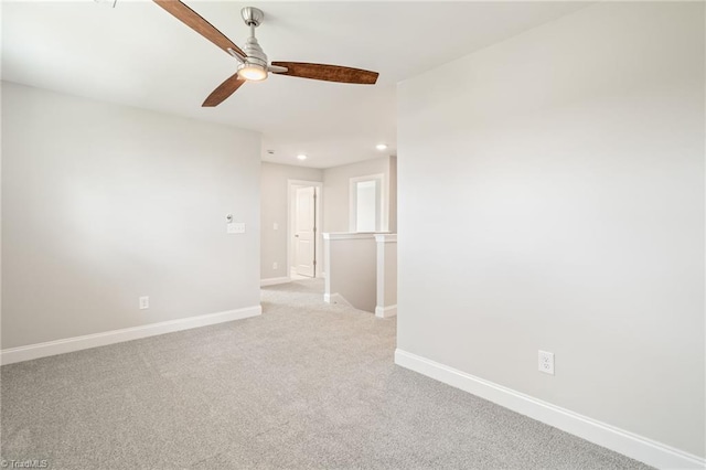 unfurnished room with light colored carpet and ceiling fan