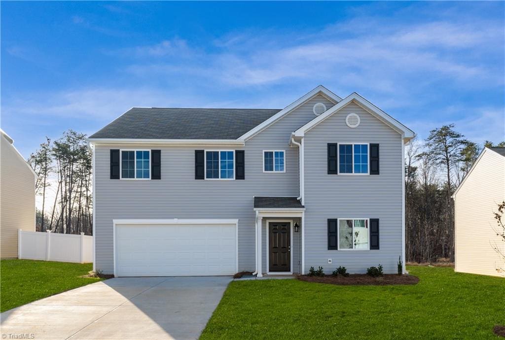 front facade with a garage and a front lawn