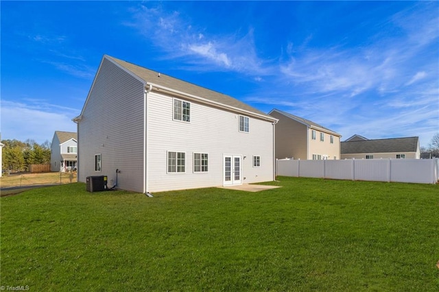 back of property with a lawn, cooling unit, and french doors