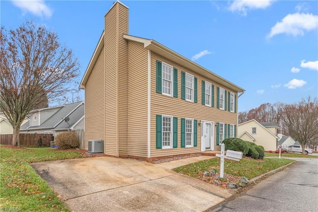 view of property exterior with central AC and a lawn