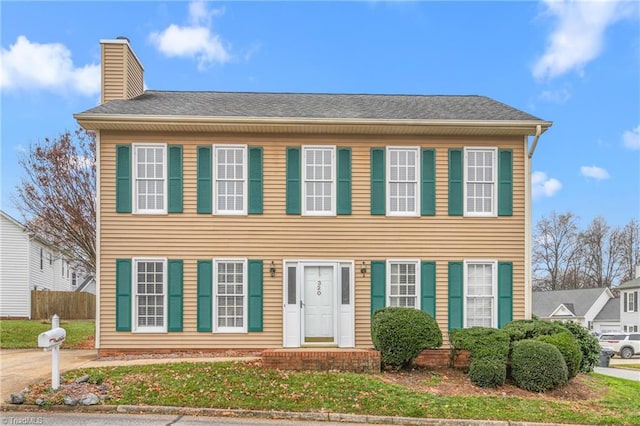 colonial home with a front lawn