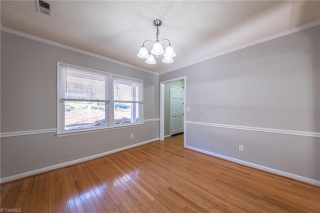 spare room with a chandelier, crown molding, a textured ceiling, and light hardwood / wood-style flooring