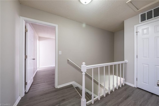 hall featuring dark hardwood / wood-style floors and a textured ceiling