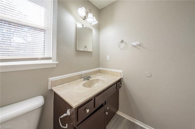 bathroom featuring wood-type flooring, vanity, and toilet