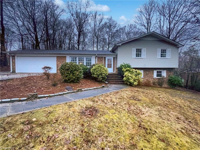 tri-level home featuring brick siding, driveway, and an attached garage