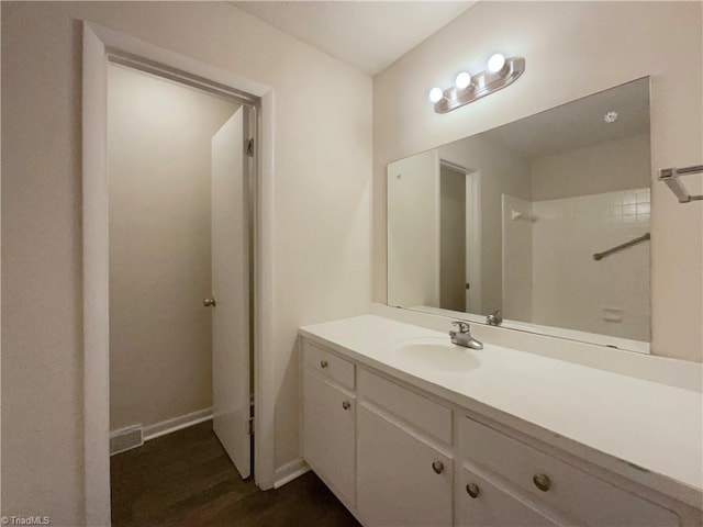 bathroom featuring wood finished floors, vanity, and baseboards