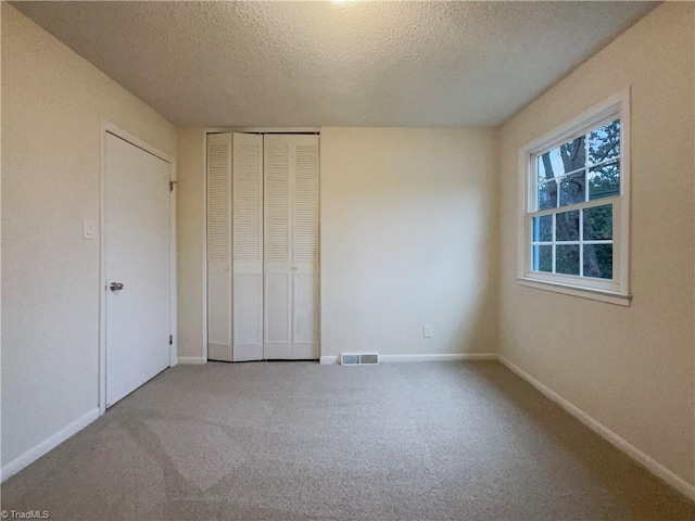 unfurnished bedroom with a closet, visible vents, and baseboards