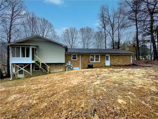 rear view of house featuring stairs, central AC, and a sunroom