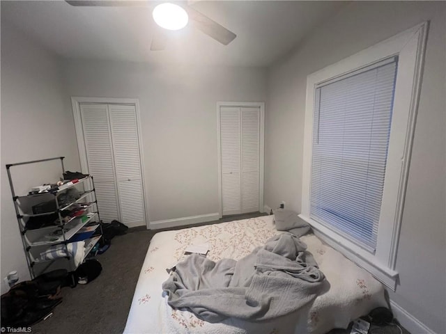 carpeted bedroom featuring ceiling fan and multiple closets