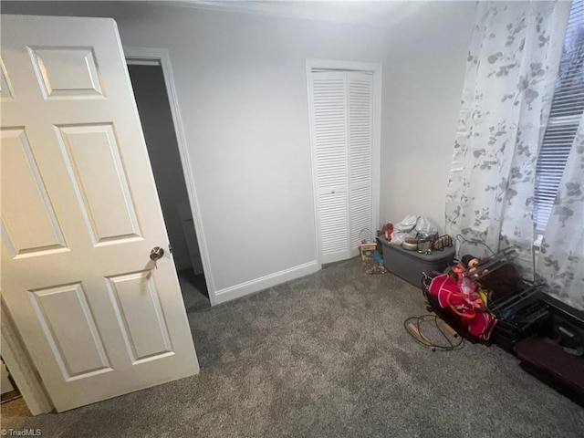 unfurnished bedroom featuring dark colored carpet and a closet