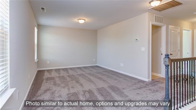 carpeted spare room featuring a healthy amount of sunlight