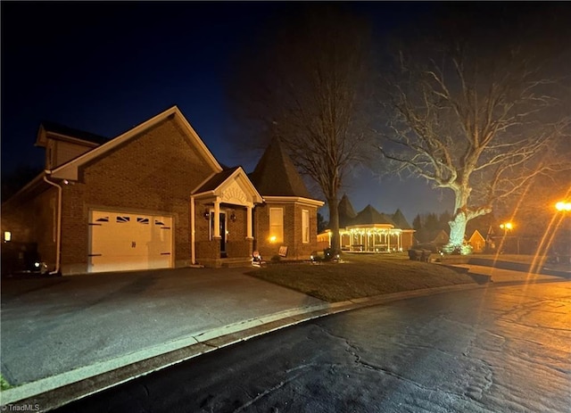 view of front facade featuring driveway, a garage, and brick siding