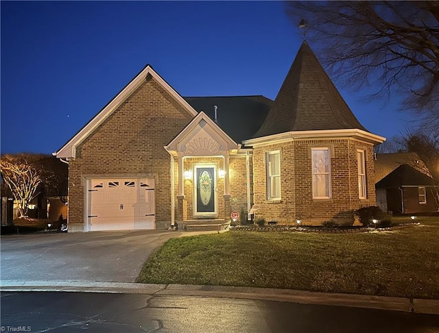 view of front facade featuring a yard, aphalt driveway, an attached garage, and brick siding