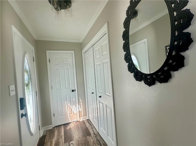 interior space featuring dark wood-style floors, crown molding, and baseboards