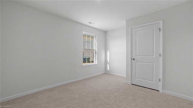 unfurnished room with baseboards, carpet floors, and visible vents