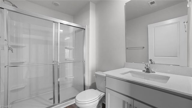 bathroom featuring visible vents, a shower stall, toilet, and vanity