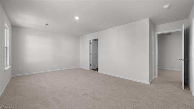 unfurnished room featuring visible vents, carpet floors, and baseboards