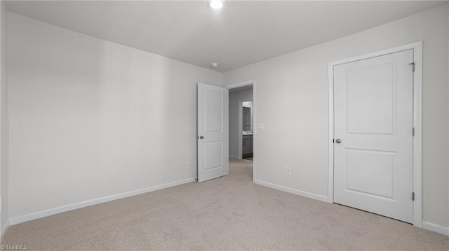 unfurnished bedroom with baseboards and light carpet