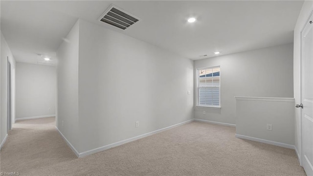 empty room featuring recessed lighting, light colored carpet, visible vents, and baseboards