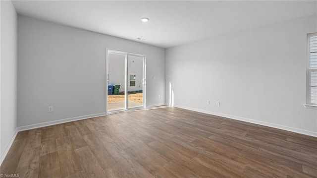 spare room featuring dark wood finished floors and baseboards