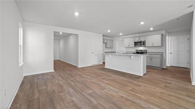 kitchen featuring light wood-style flooring, recessed lighting, baseboards, and appliances with stainless steel finishes