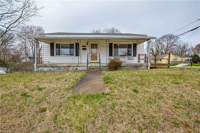 bungalow-style home with a front lawn, fence, and covered porch