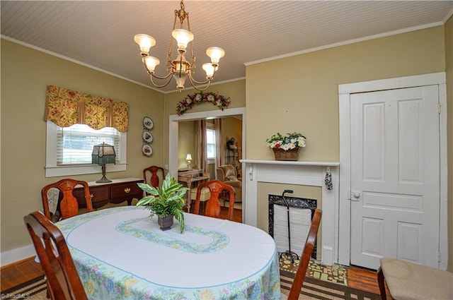 dining space with a wealth of natural light, a notable chandelier, wood finished floors, and crown molding