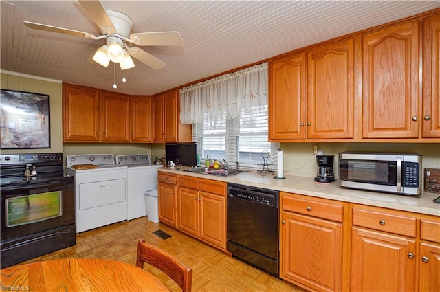 kitchen with washer and clothes dryer, light countertops, brown cabinets, black appliances, and a sink