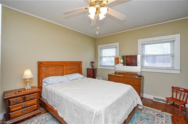 bedroom with hardwood / wood-style floors, a ceiling fan, baseboards, and ornamental molding