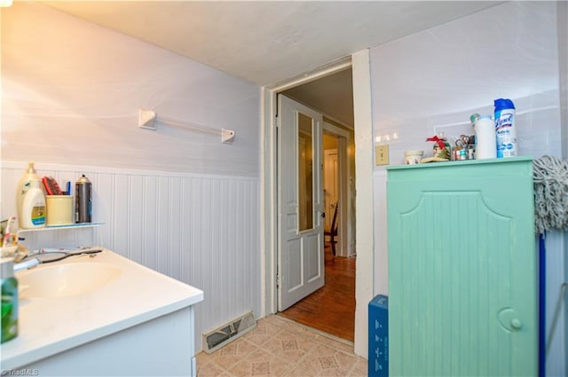 bathroom with a sink, visible vents, and wainscoting