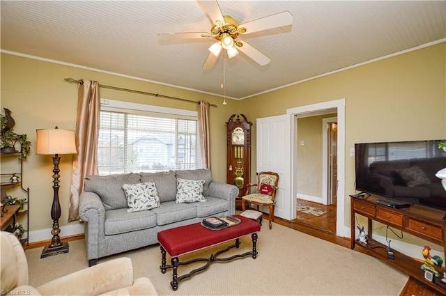 living room featuring a ceiling fan, baseboards, and ornamental molding