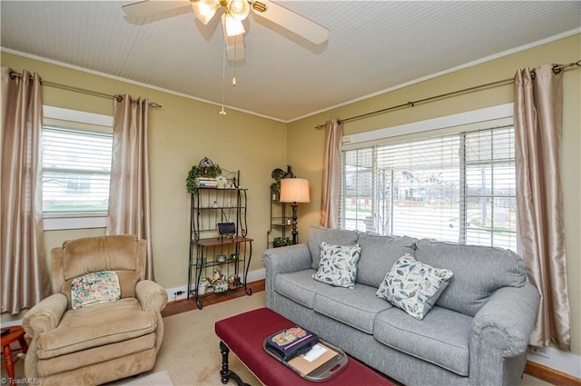 living area with plenty of natural light, baseboards, crown molding, and a ceiling fan