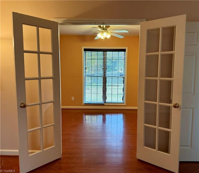 spare room with a textured ceiling, ceiling fan, french doors, and dark hardwood / wood-style floors