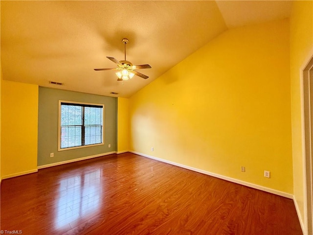 empty room with ceiling fan, wood-type flooring, and vaulted ceiling