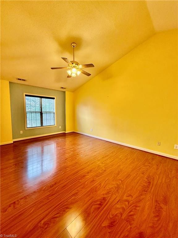 unfurnished room with a textured ceiling, ceiling fan, hardwood / wood-style floors, and lofted ceiling