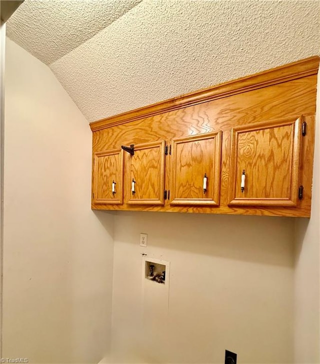 laundry room featuring hookup for a washing machine, cabinets, a textured ceiling, and hookup for an electric dryer