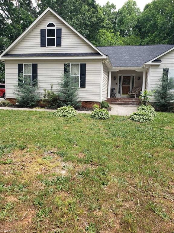 back of property featuring a lawn and a porch