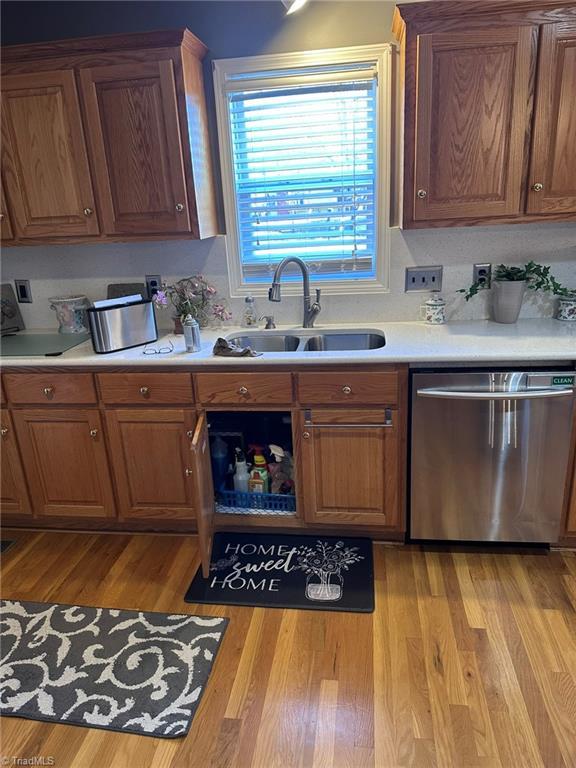 kitchen featuring dishwasher, sink, and light hardwood / wood-style flooring