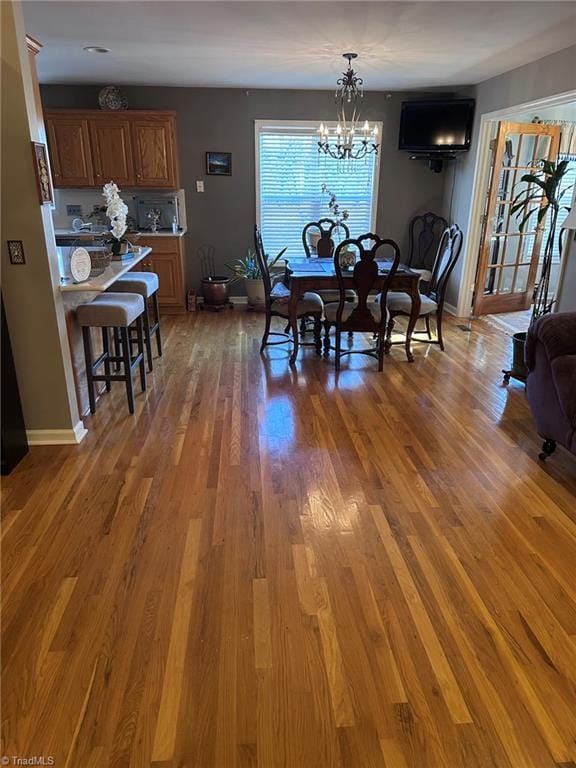 dining space with dark hardwood / wood-style floors and an inviting chandelier