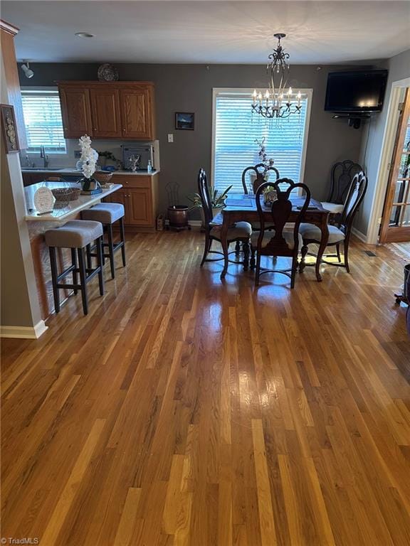 dining area with dark hardwood / wood-style flooring and a chandelier