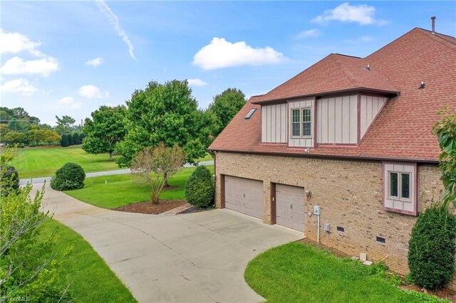 view of side of property with a garage and a lawn